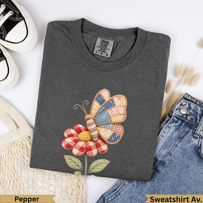 Dark gray t-shirt with a patchwork butterfly and flower graphic.