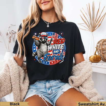 Black t-shirt with raccoon wearing sunglasses and holding a hot dog, "Red White and Feral" text.