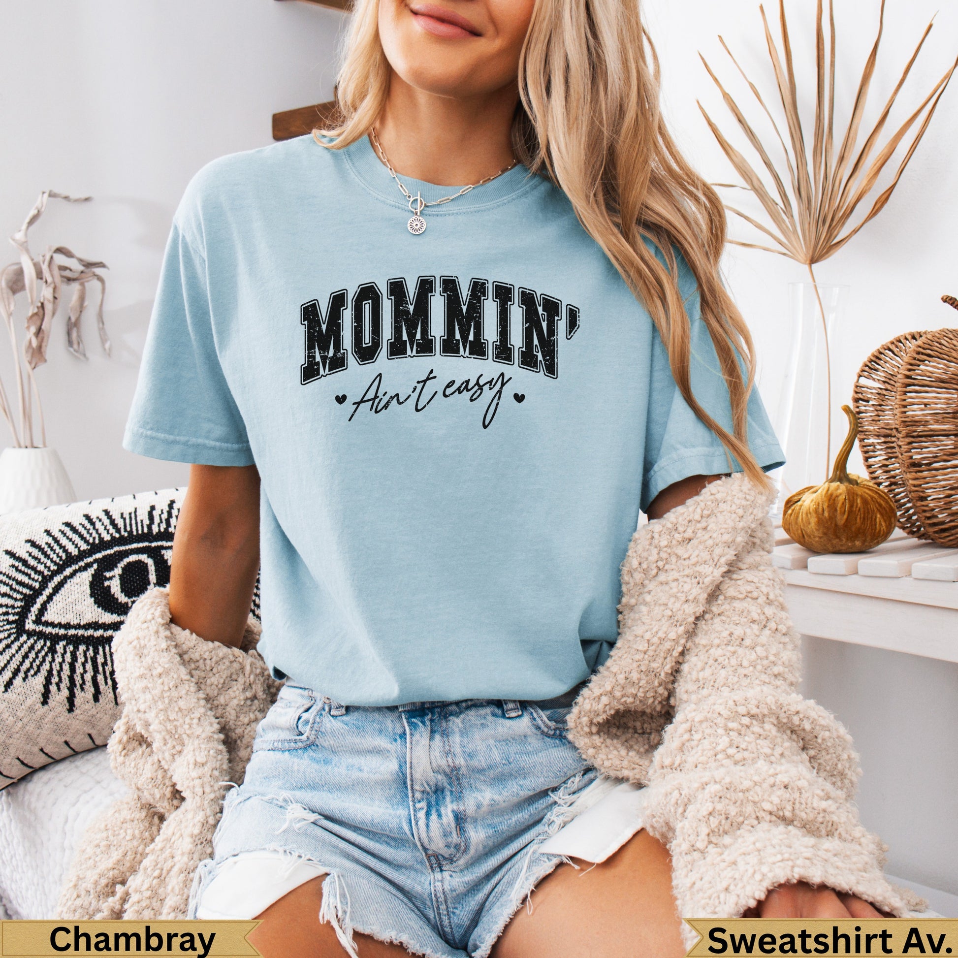 Light blue t-shirt with "MOMMIN' Ain't easy" text on chest.