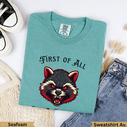 Teal sweatshirt with "FIRST OF ALL" and a raccoon graphic.