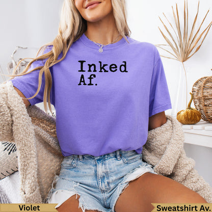 Purple t-shirt with "Inked Af." text, worn by a model.