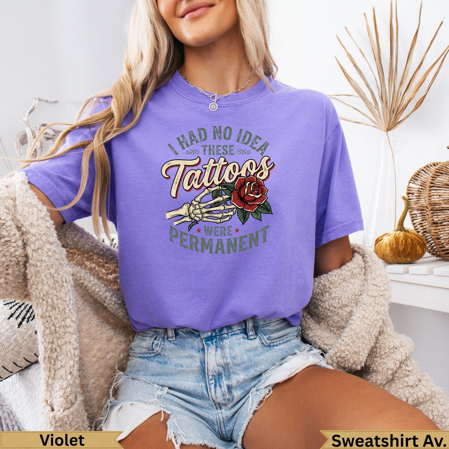 Purple t-shirt with "I had no idea these tattoos were permanent" and skeletal hand holding rose.