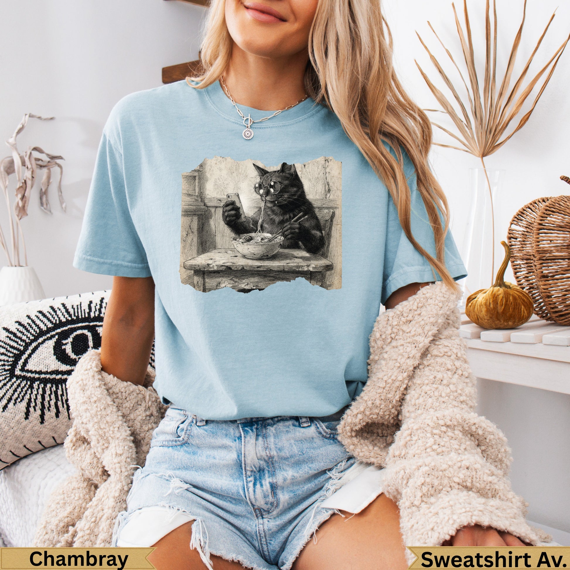 Light blue t-shirt with vintage black cat graphic eating from a bowl.