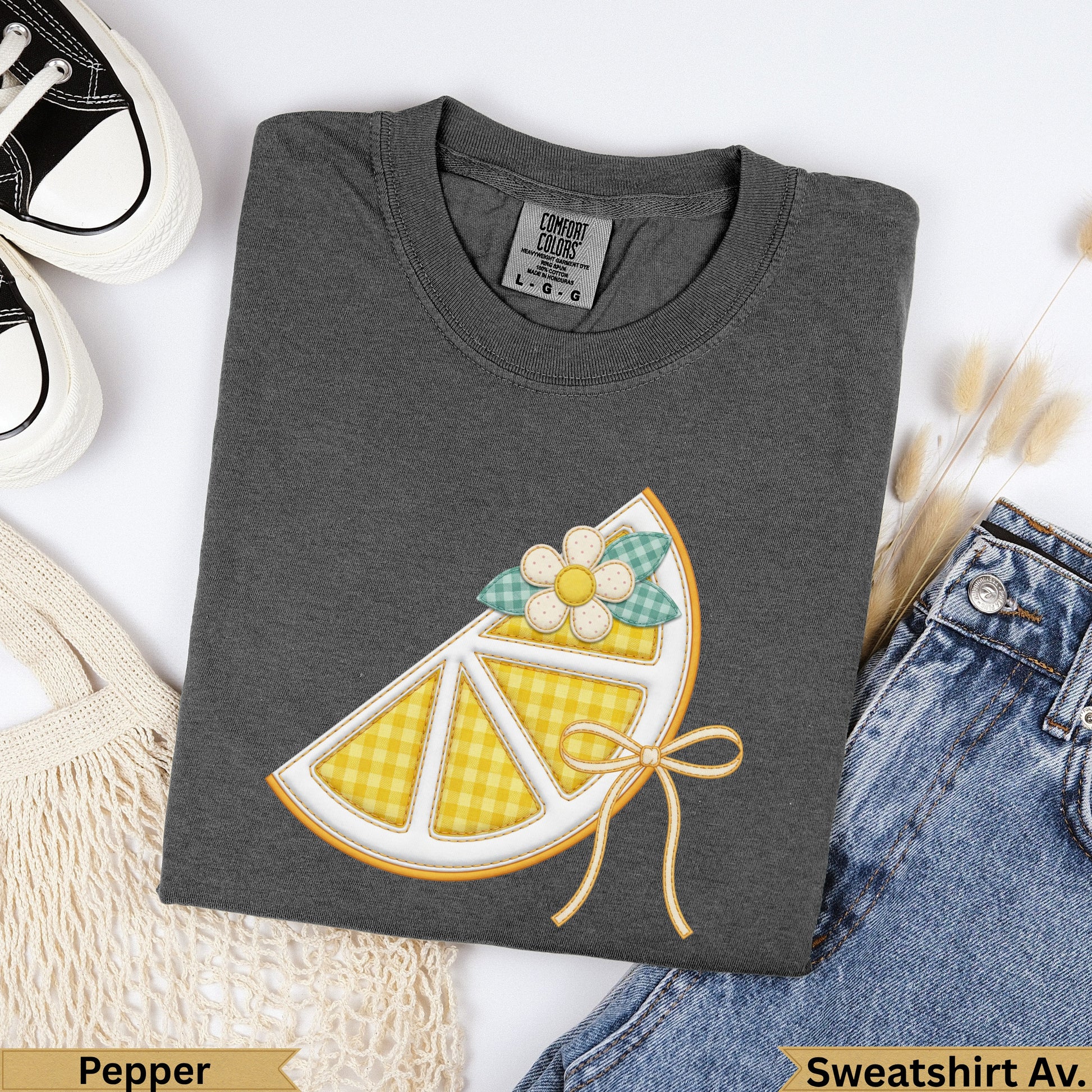 Dark grey t-shirt with embroidered lemon slice graphic and bow.