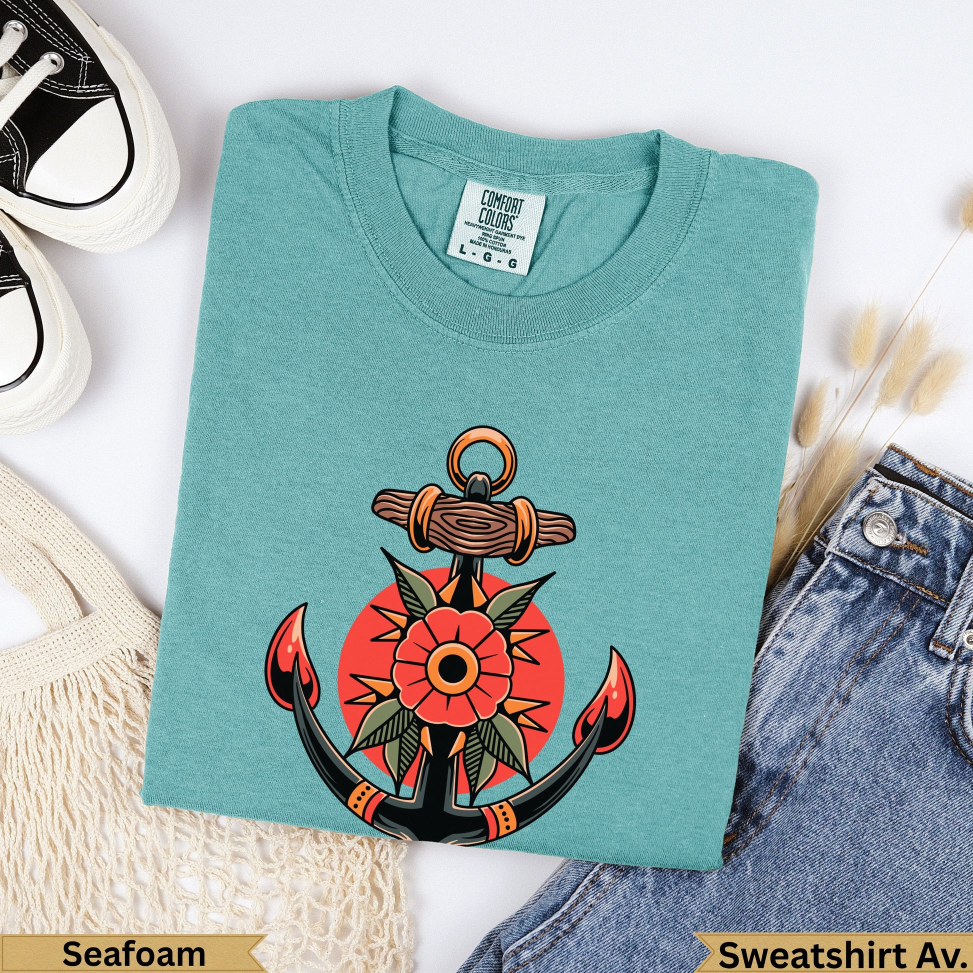 Teal sweatshirt with traditional anchor and flower tattoo design.