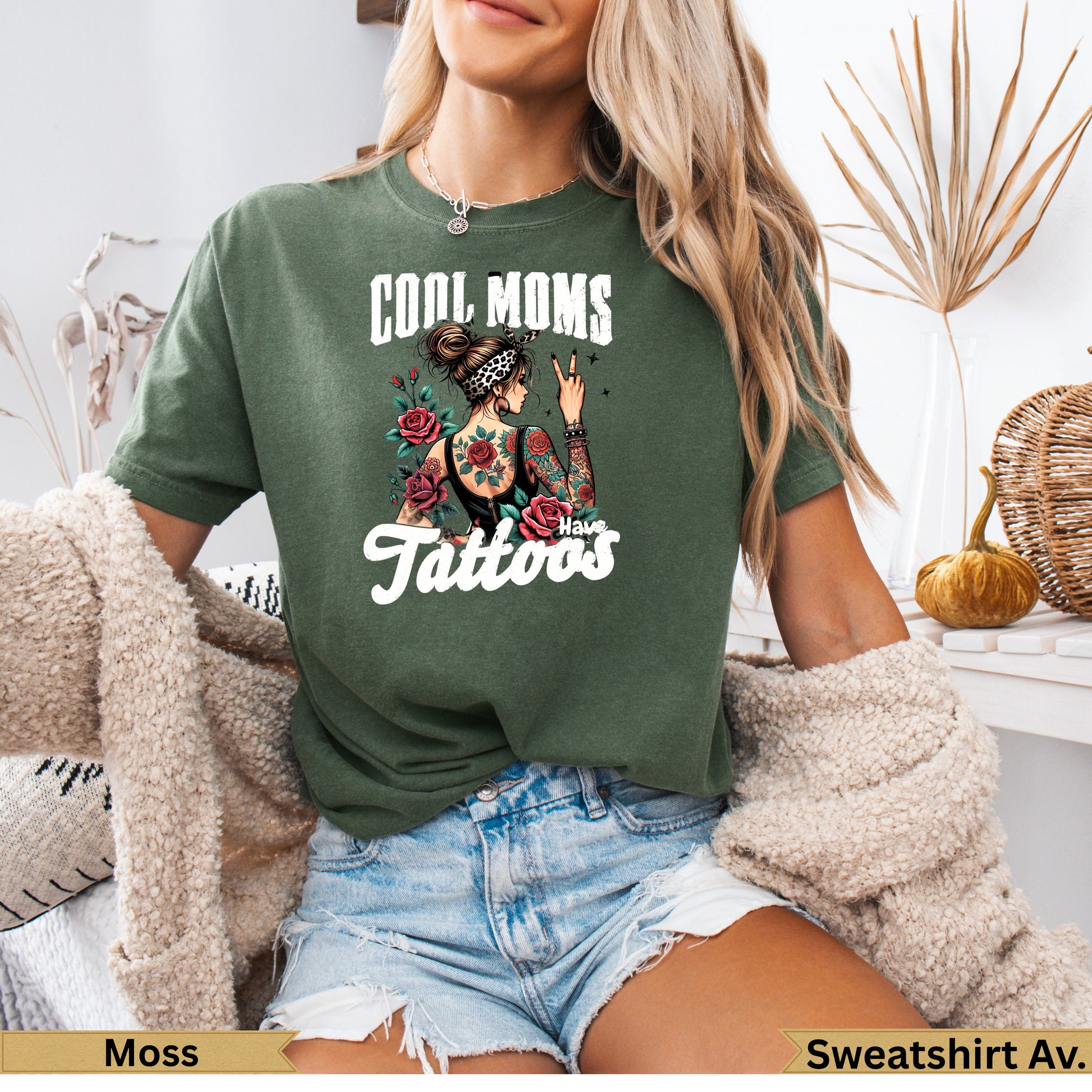 Green t-shirt with "Cool Moms Have Tattoos" graphic and floral accents.