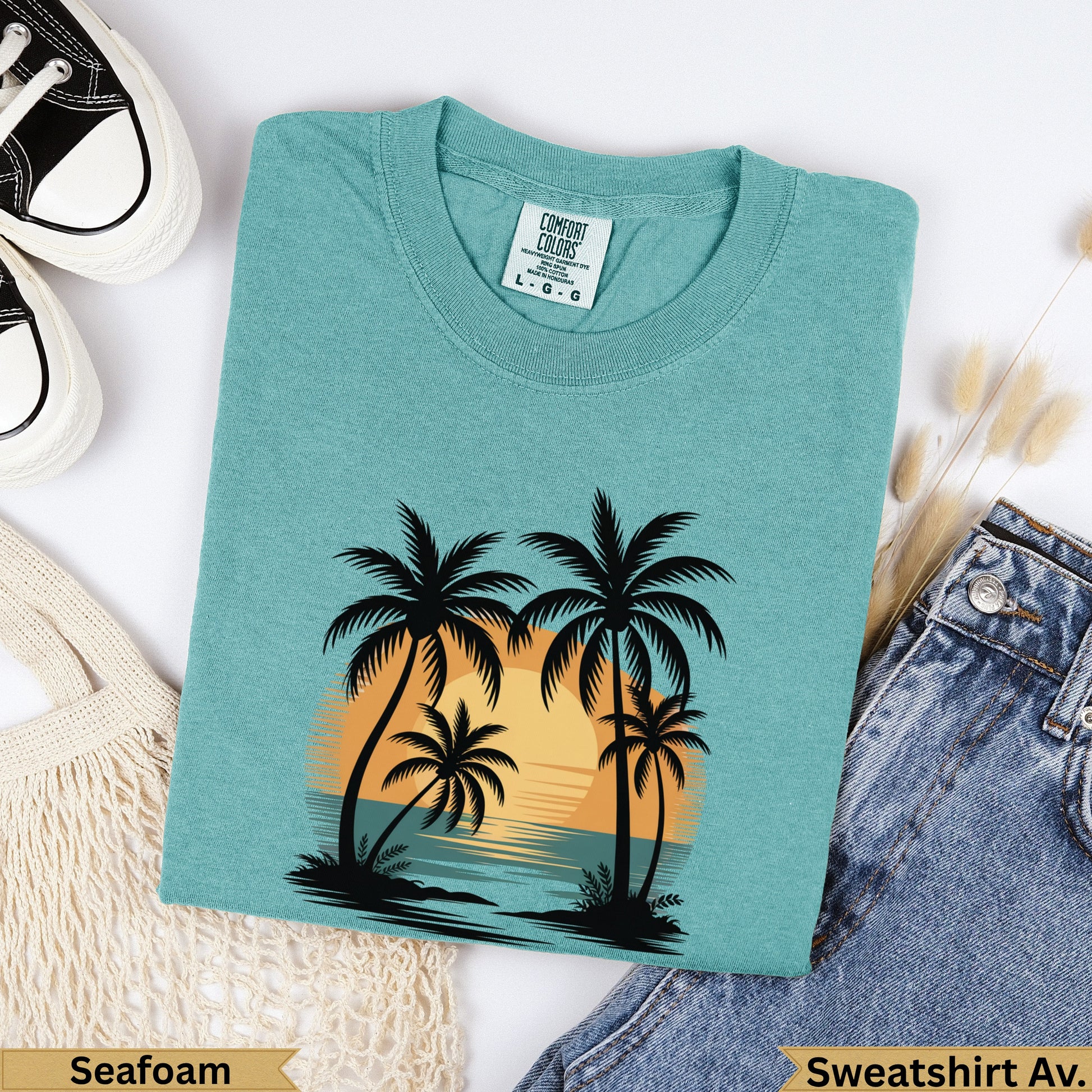 Teal sweatshirt with sunset palm trees graphic, "Seafoam" text.