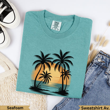 Teal sweatshirt with sunset palm trees graphic, "Seafoam" text.
