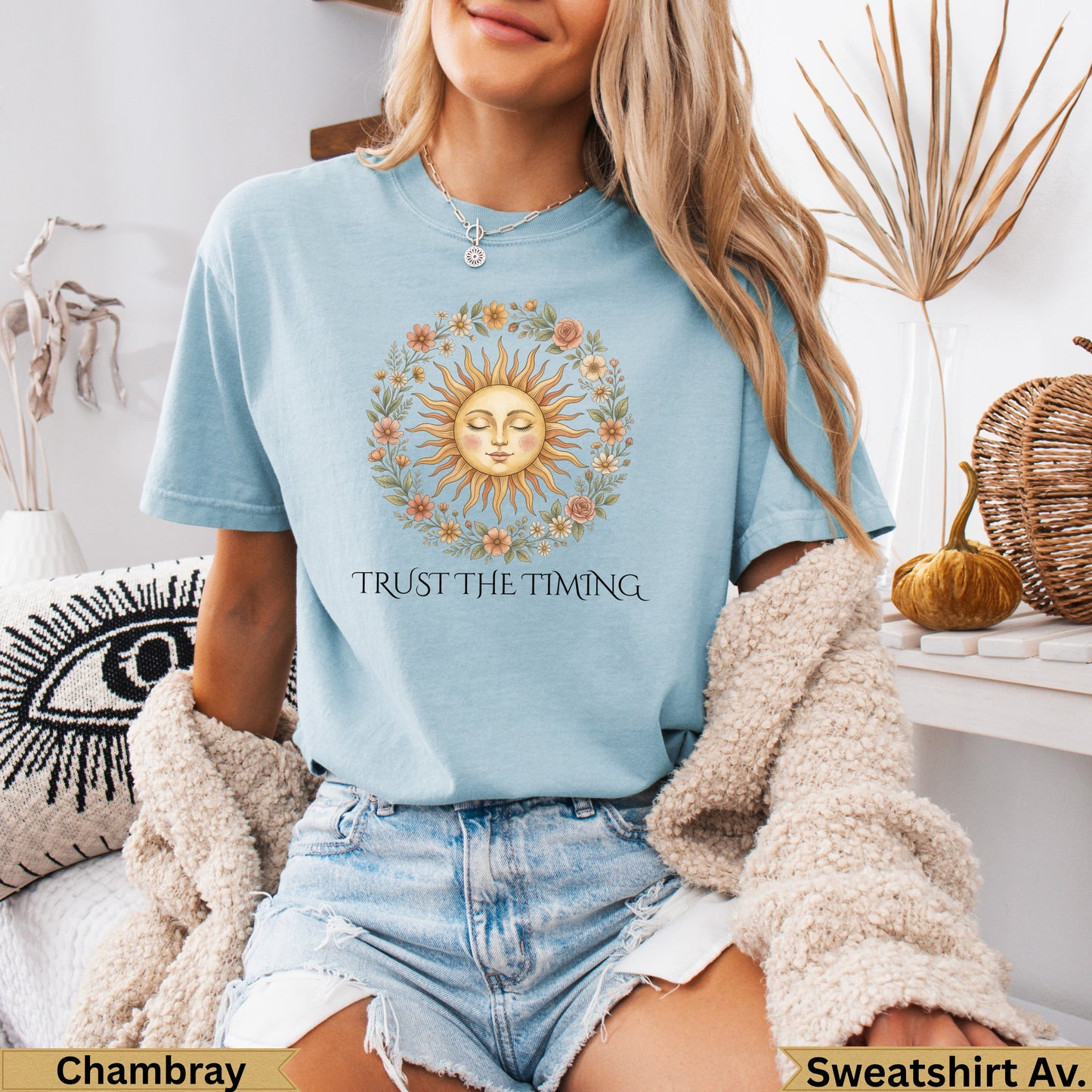 Light blue t-shirt with a sun and floral wreath graphic and text "TRUST THE TIMING".
