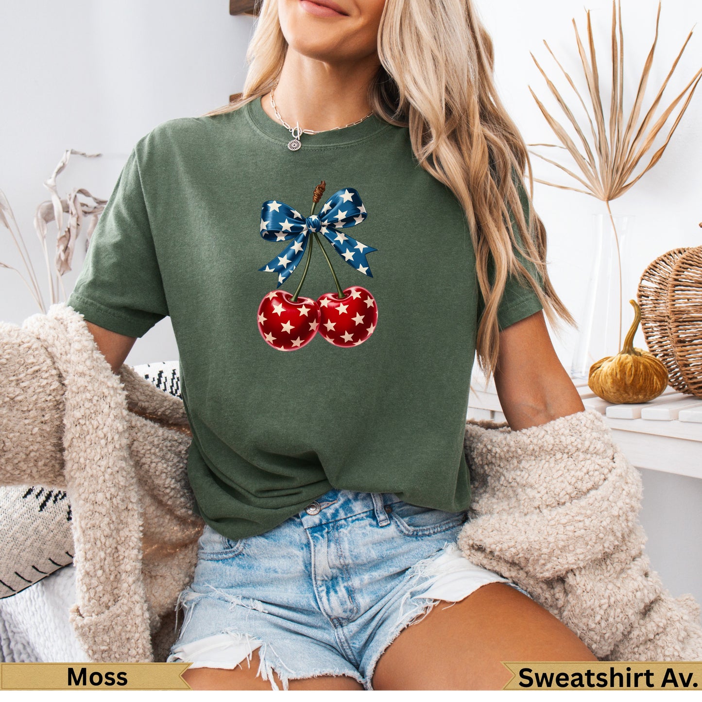 Green t-shirt with cherries adorned with a red, white, and blue star bow.