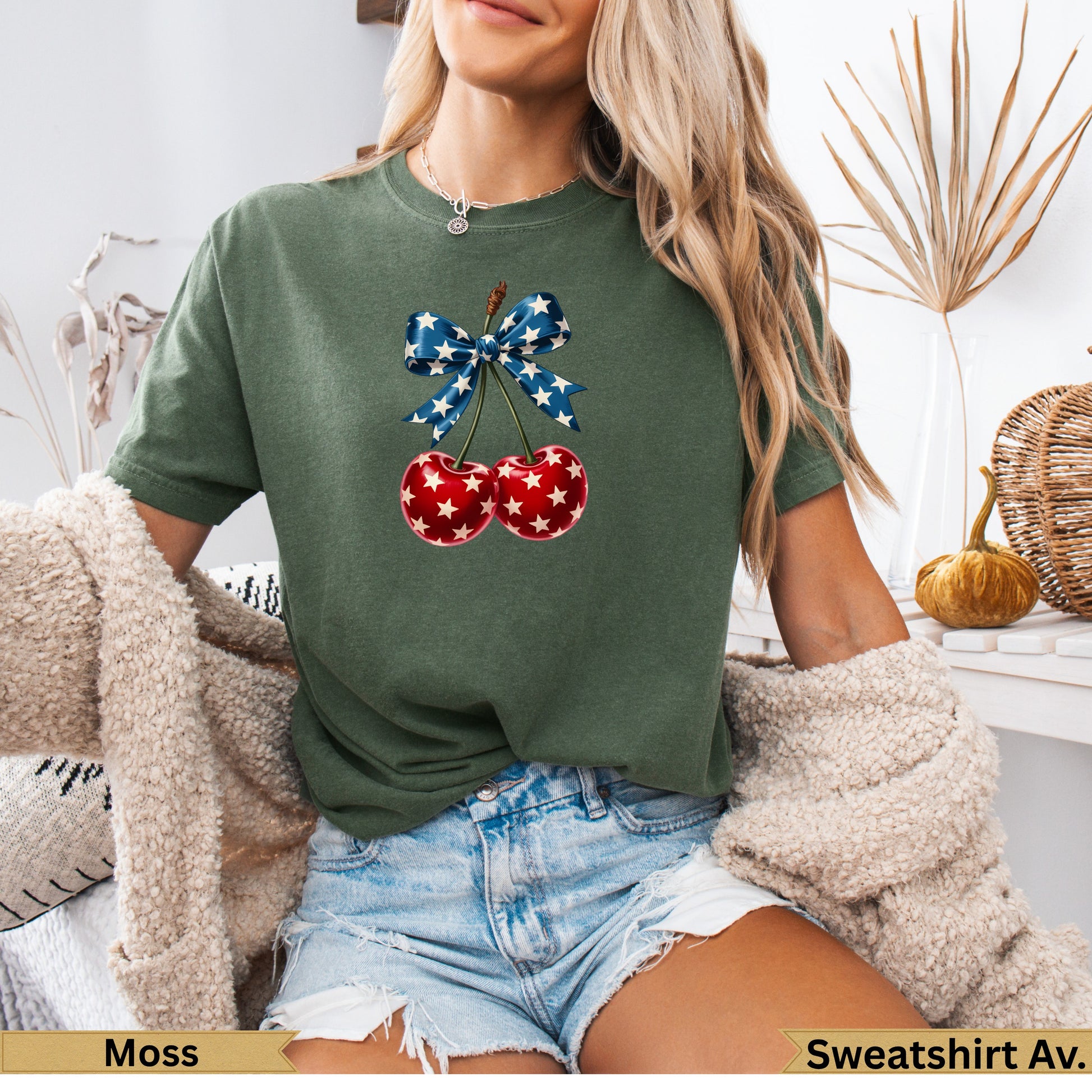 Green t-shirt with cherries adorned with a red, white, and blue star bow.