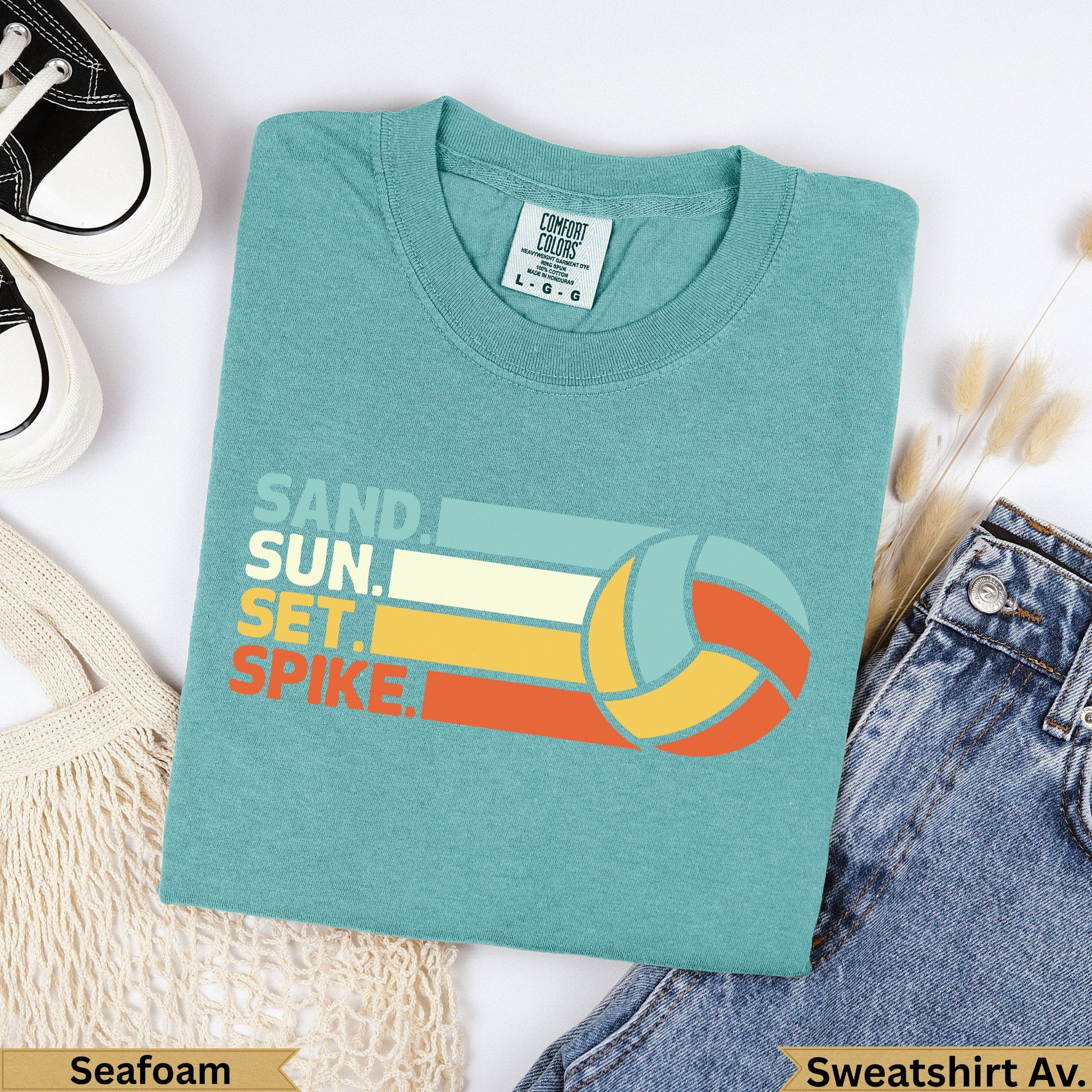 Teal t-shirt with "SAND. SUN. SET. SPIKE." text and a volleyball.