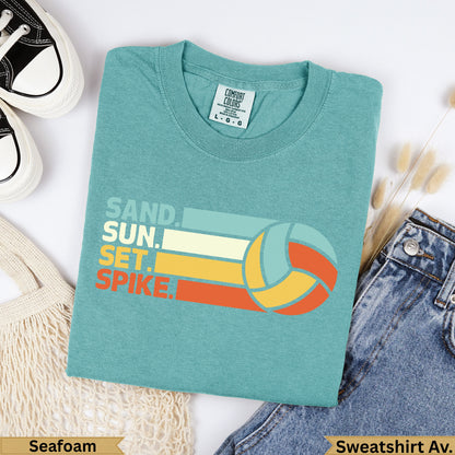 Teal t-shirt with "SAND. SUN. SET. SPIKE." text and a volleyball.