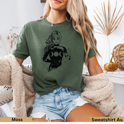 Woman wearing olive green t-shirt with celestial goddess graphic.