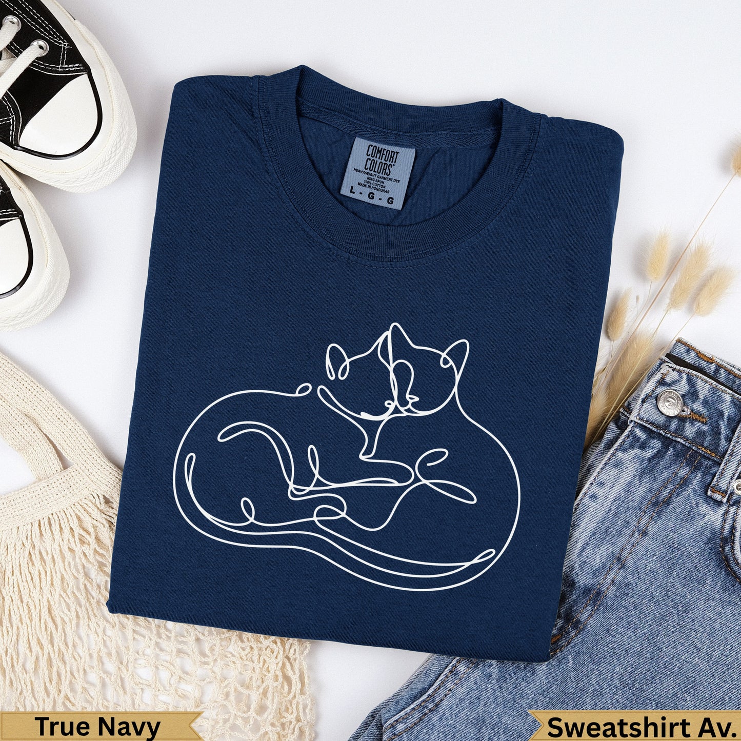 Navy blue sweatshirt with two white line-art cats embracing.
