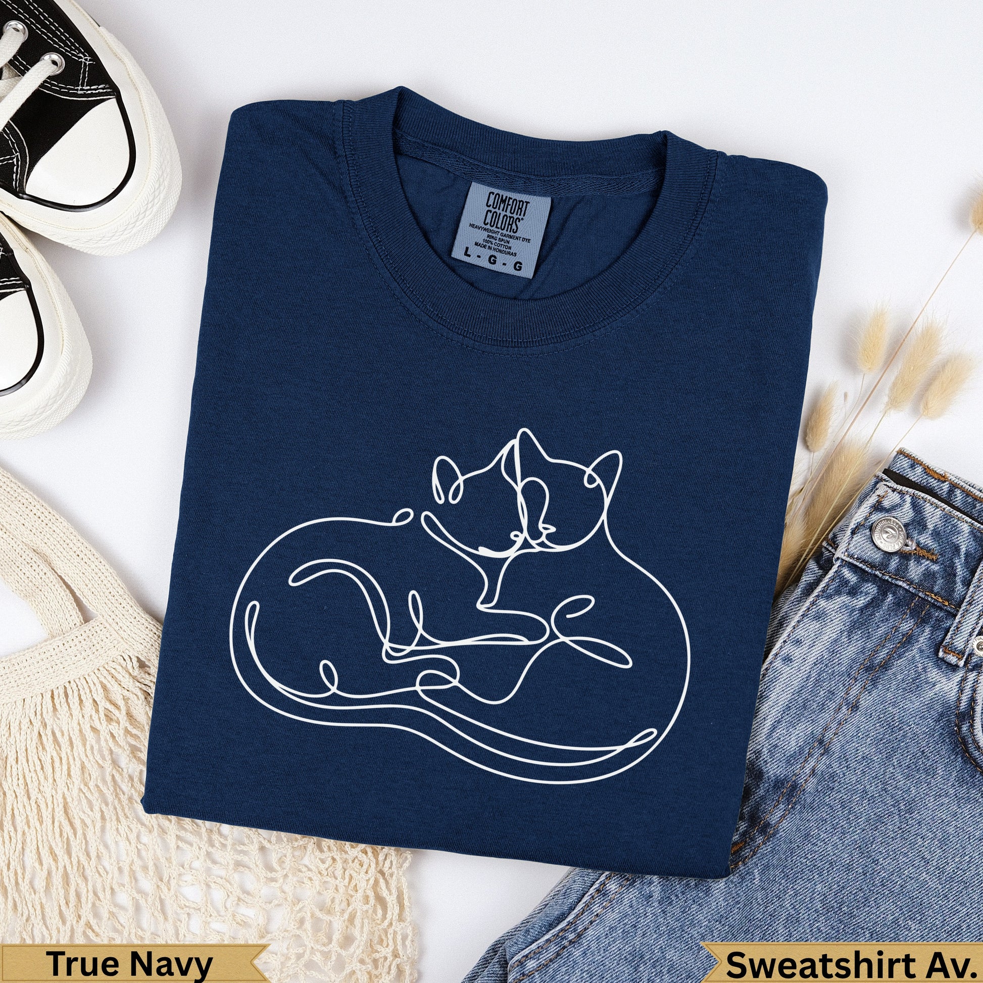 Navy blue sweatshirt with two white line-art cats embracing.