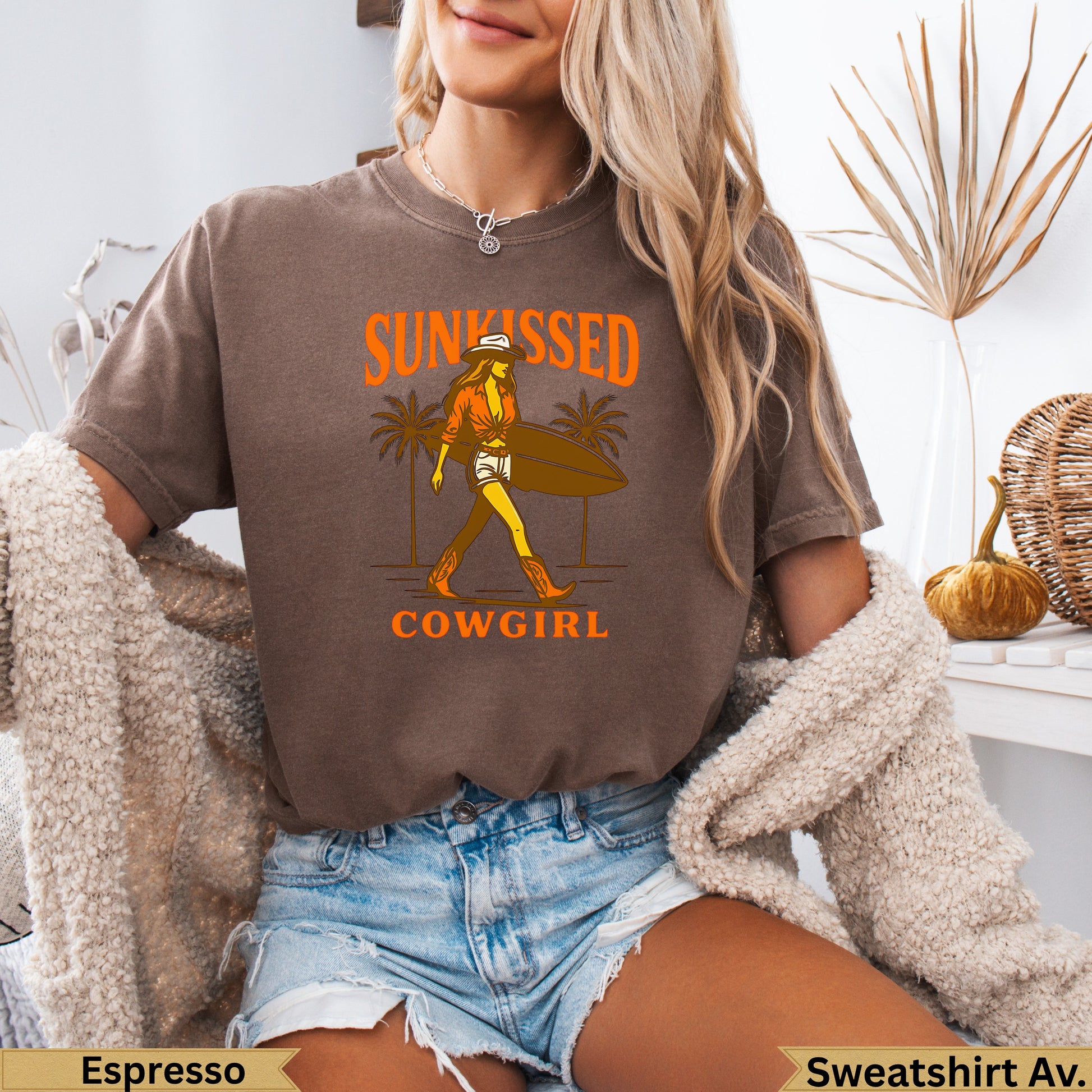 Brown t-shirt with "Sunkissed Cowgirl" text and graphic of woman with surfboard.
