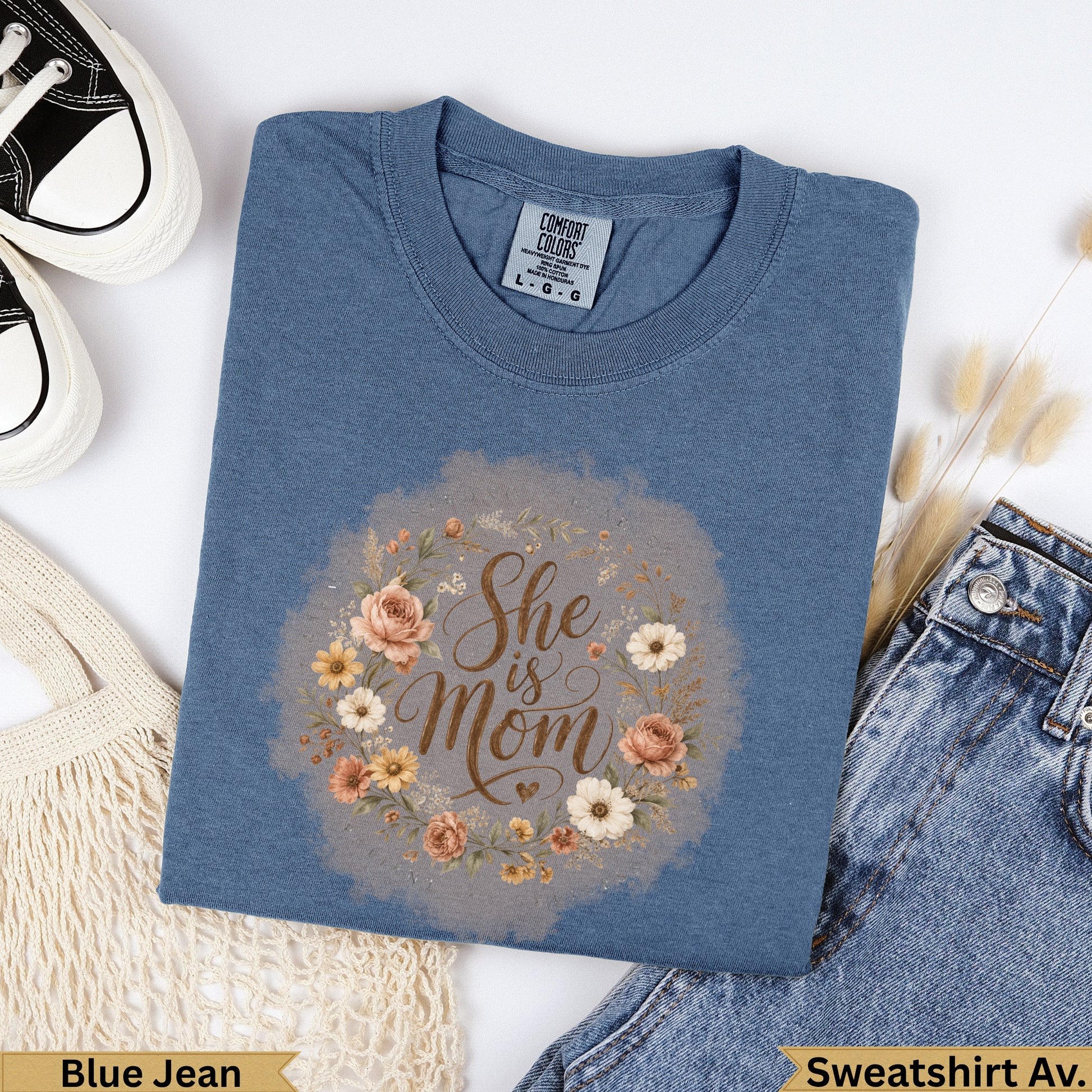 Blue Jean Comfort Colors sweatshirt with "She is Mom" floral wreath graphic.