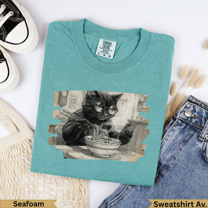 Black cat wearing glasses eats ramen, printed on a seafoam Comfort Colors sweatshirt.