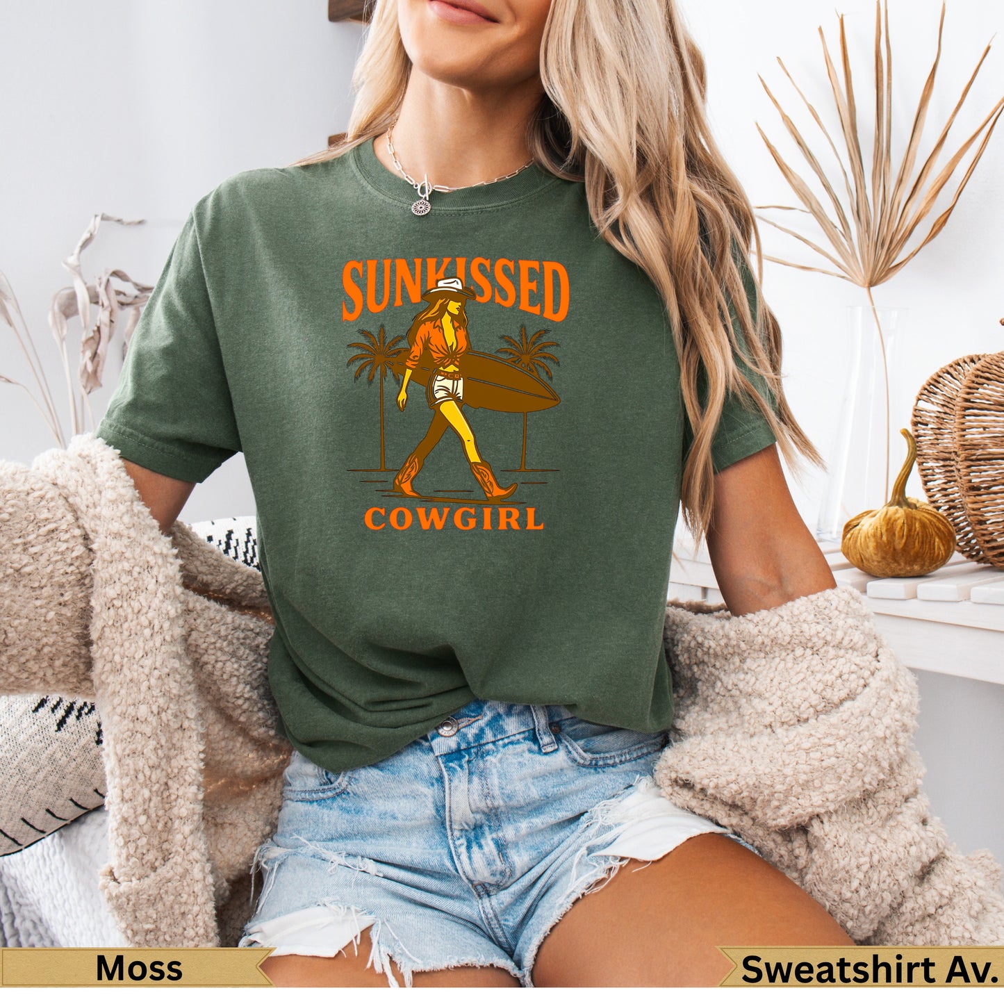 Green t-shirt with "SUNKISSED COWGAL" text and surfing woman graphic.