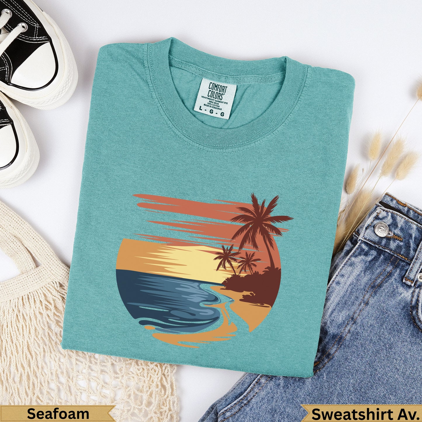 Teal t-shirt with sunset beach graphic, "Seafoam" and "Sweatshirt Av." text.