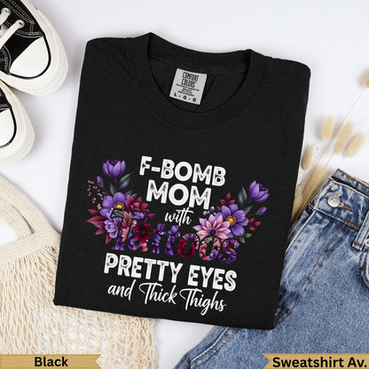 Black t-shirt with "F-BOMB MOM with PRETTY EYES and Thick Thighs" text and floral design.