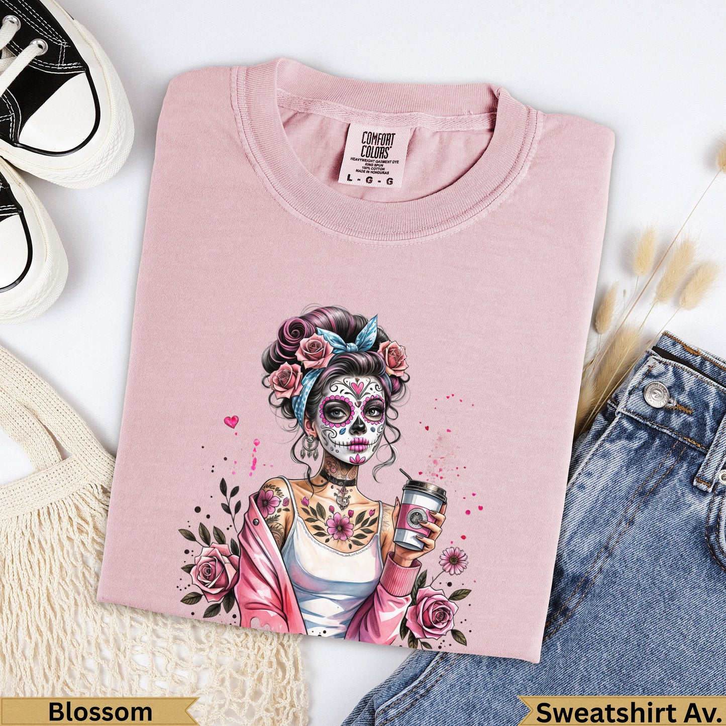 Pink crewneck t-shirt with a skull adorned woman holding a coffee cup.