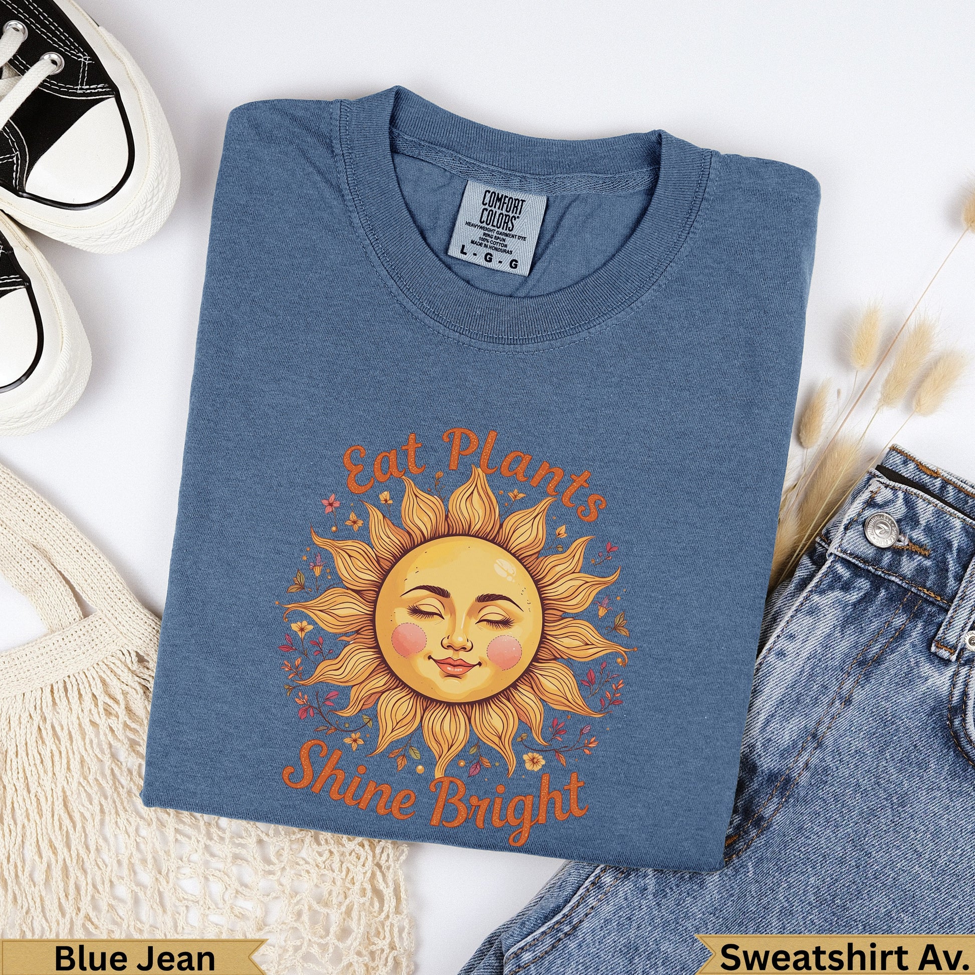 Blue t-shirt with "Eat Plants Shine Bright" sun graphic.