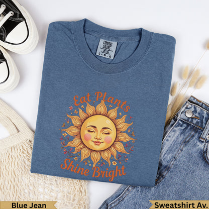 Blue t-shirt with "Eat Plants Shine Bright" sun graphic.