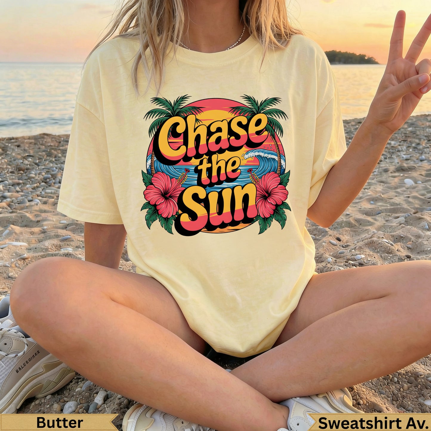 Yellow "Chase the Sun" sweatshirt with hibiscus flowers and palm trees, worn by a person on a beach.