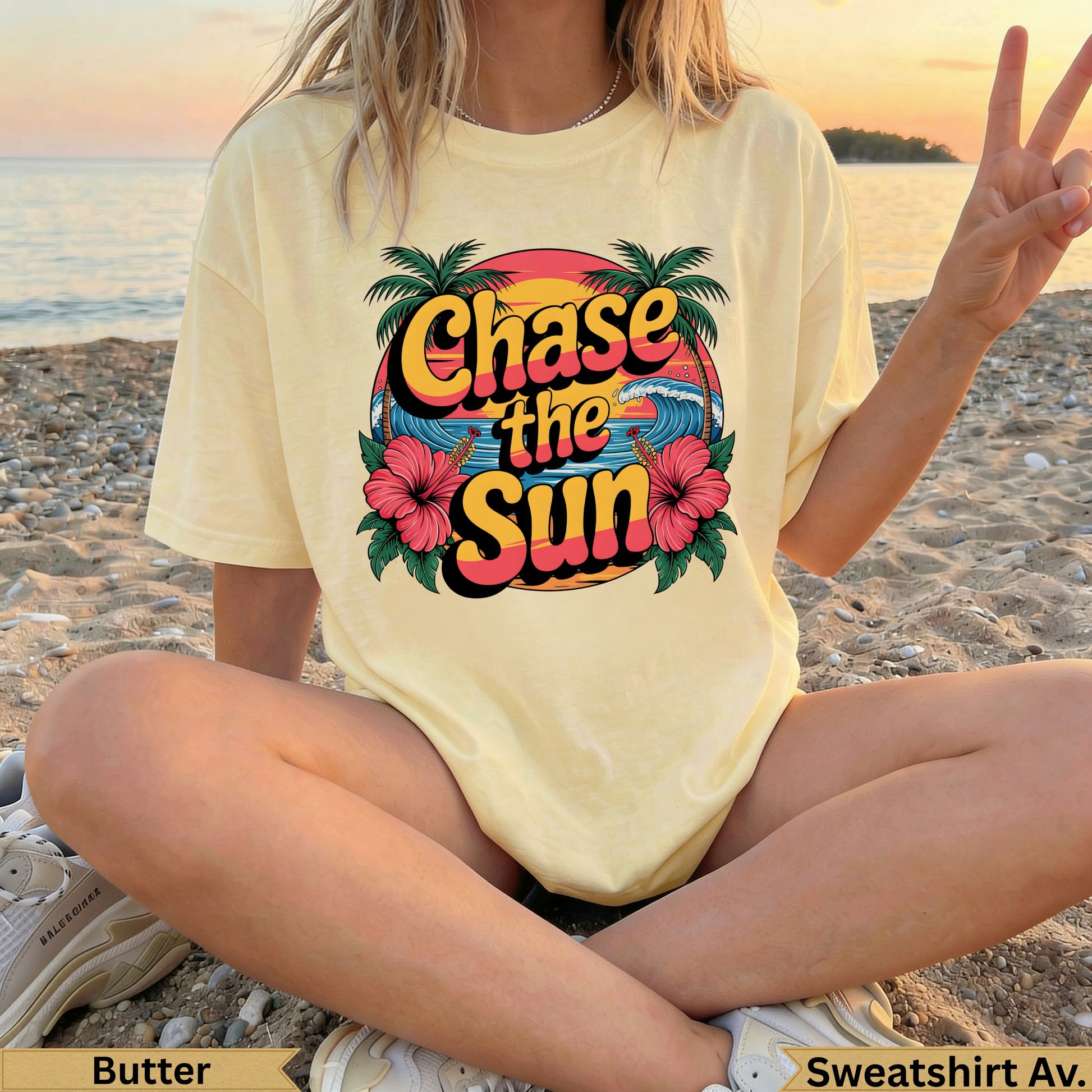Yellow "Chase the Sun" sweatshirt with hibiscus flowers and palm trees, worn by a person on a beach.