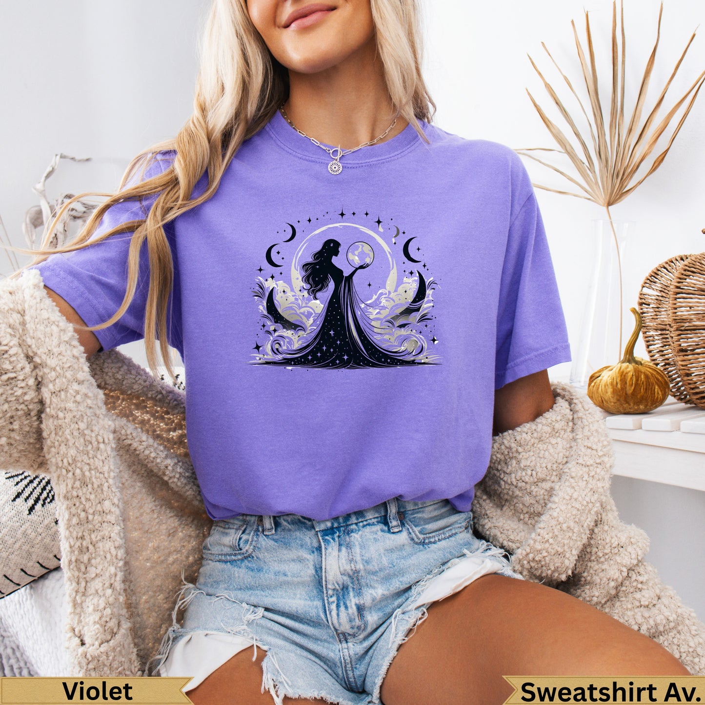 Woman wearing a purple t-shirt with a celestial moon and star graphic.