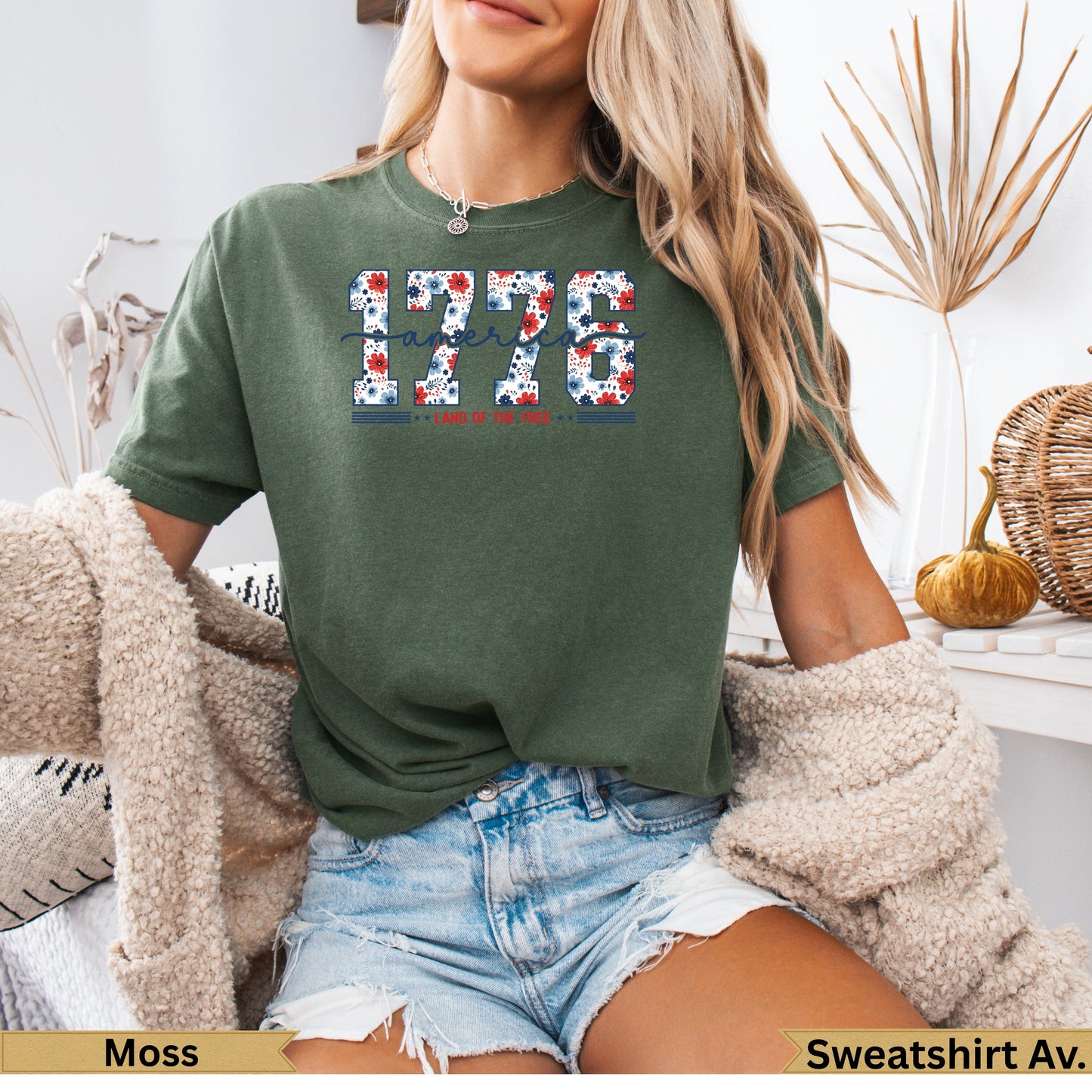 Green t-shirt with "1776 LAND OF THE FREE" design in red, white, and blue floral pattern.
