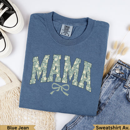 Blue t-shirt with "MAMA" in floral pattern, next to jeans and bag.
