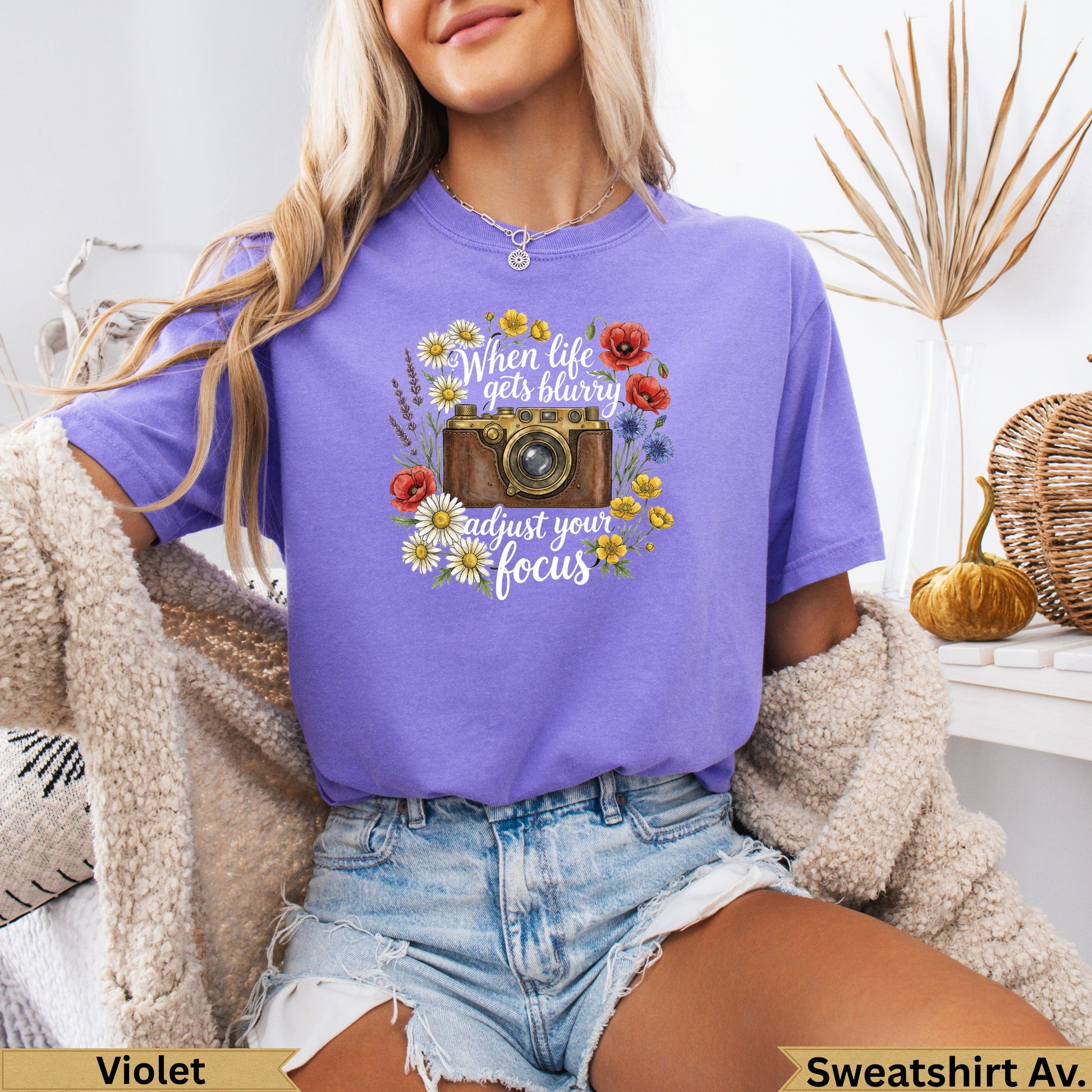 T-shirt with vintage camera and floral design, text "When life gets blurry adjust your focus".