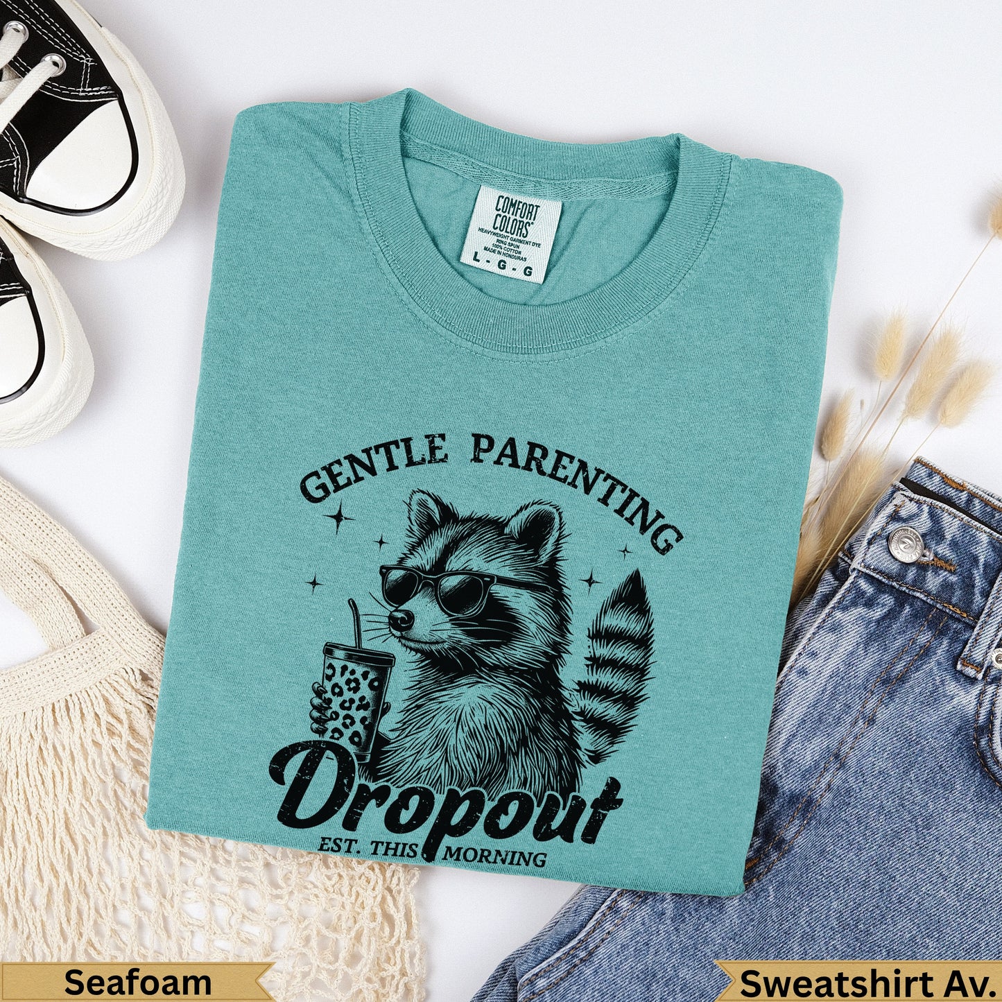 Teal t-shirt with raccoon wearing sunglasses and holding a drink, "Gentle Parenting Dropout" text.