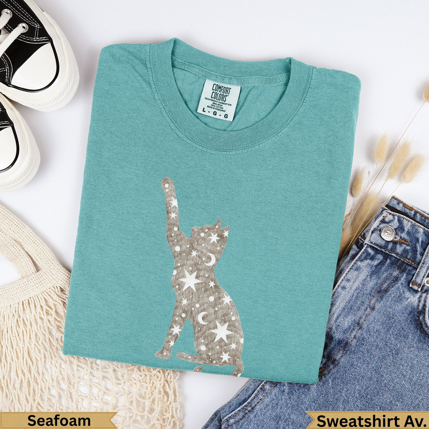Teal crewneck t-shirt with a celestial cat graphic.