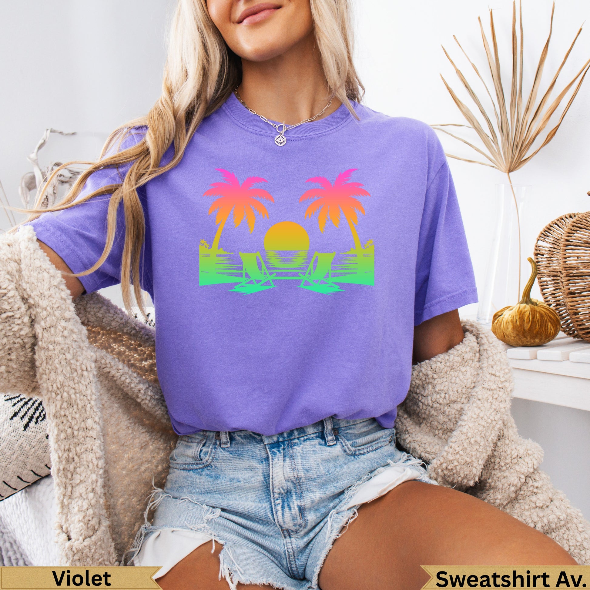 T-shirt with purple, orange, and green palm trees and lounge chairs.