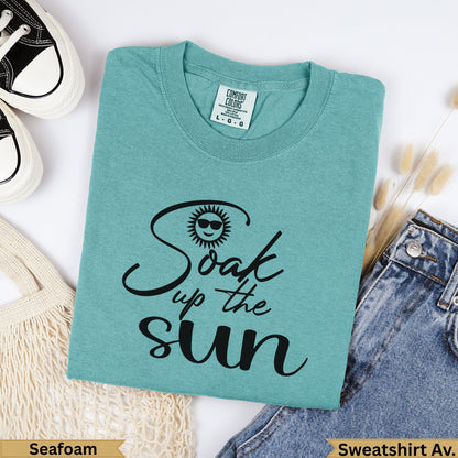Teal t-shirt with "Soak up the sun" text and sun graphic.
