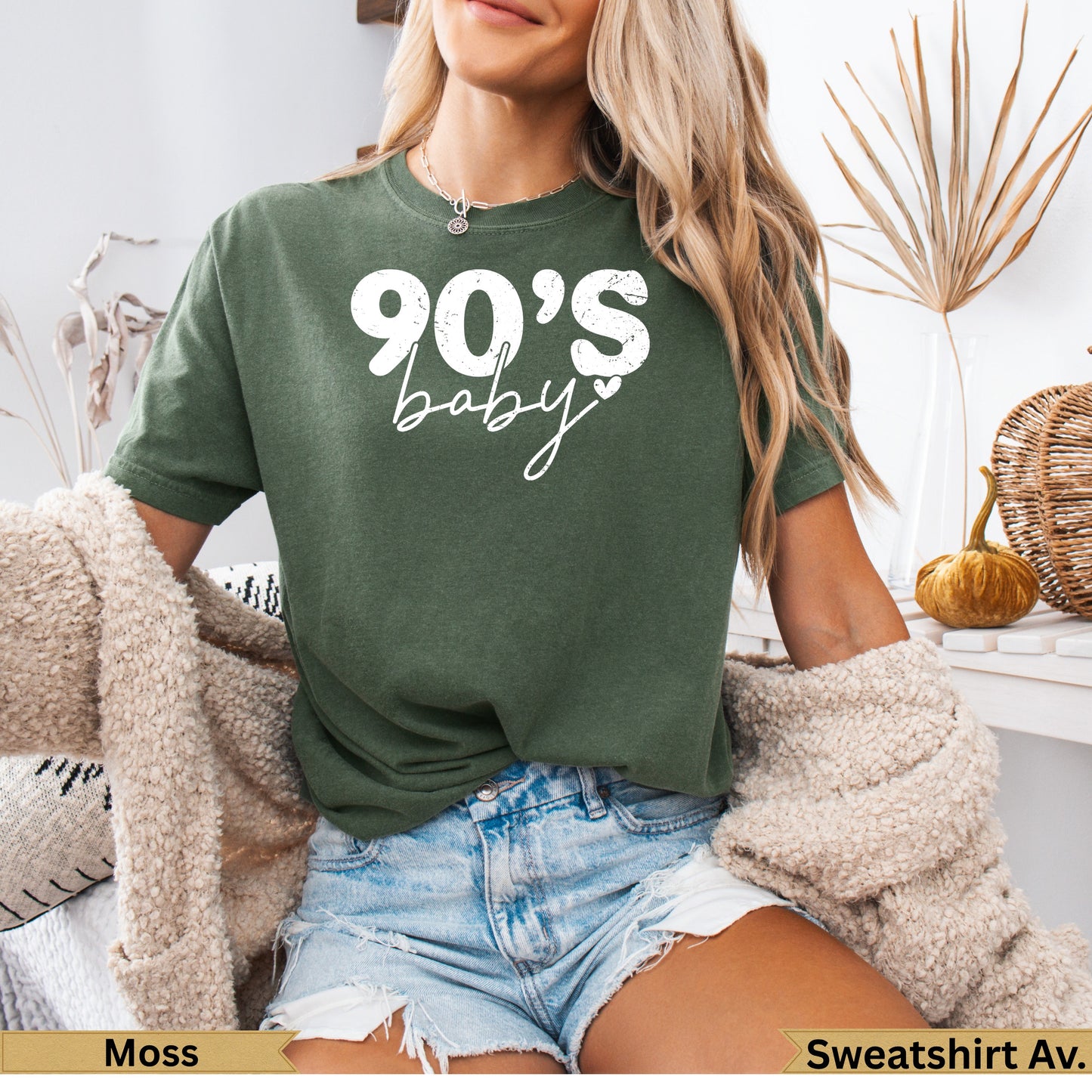 Green t-shirt with white text "90's baby" and heart, worn by a woman.