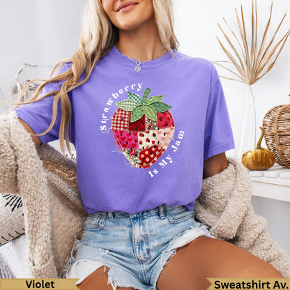 Purple t-shirt with a patchwork strawberry graphic and "Strawberry Is My Jam" text.