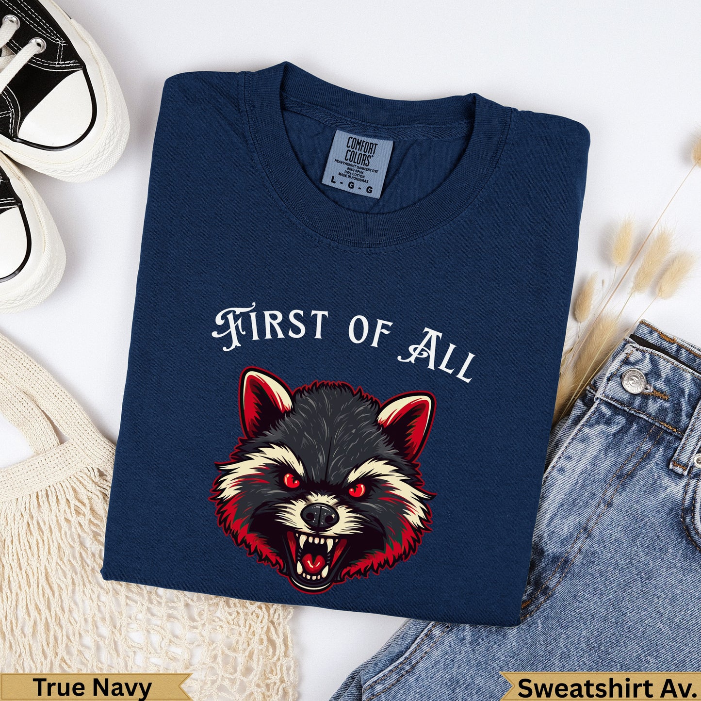 Navy t-shirt with a fierce raccoon graphic and "FIRST OF ALL" text.