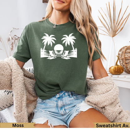 Green t-shirt with white graphic of two palm trees, beach chairs, and sun.
