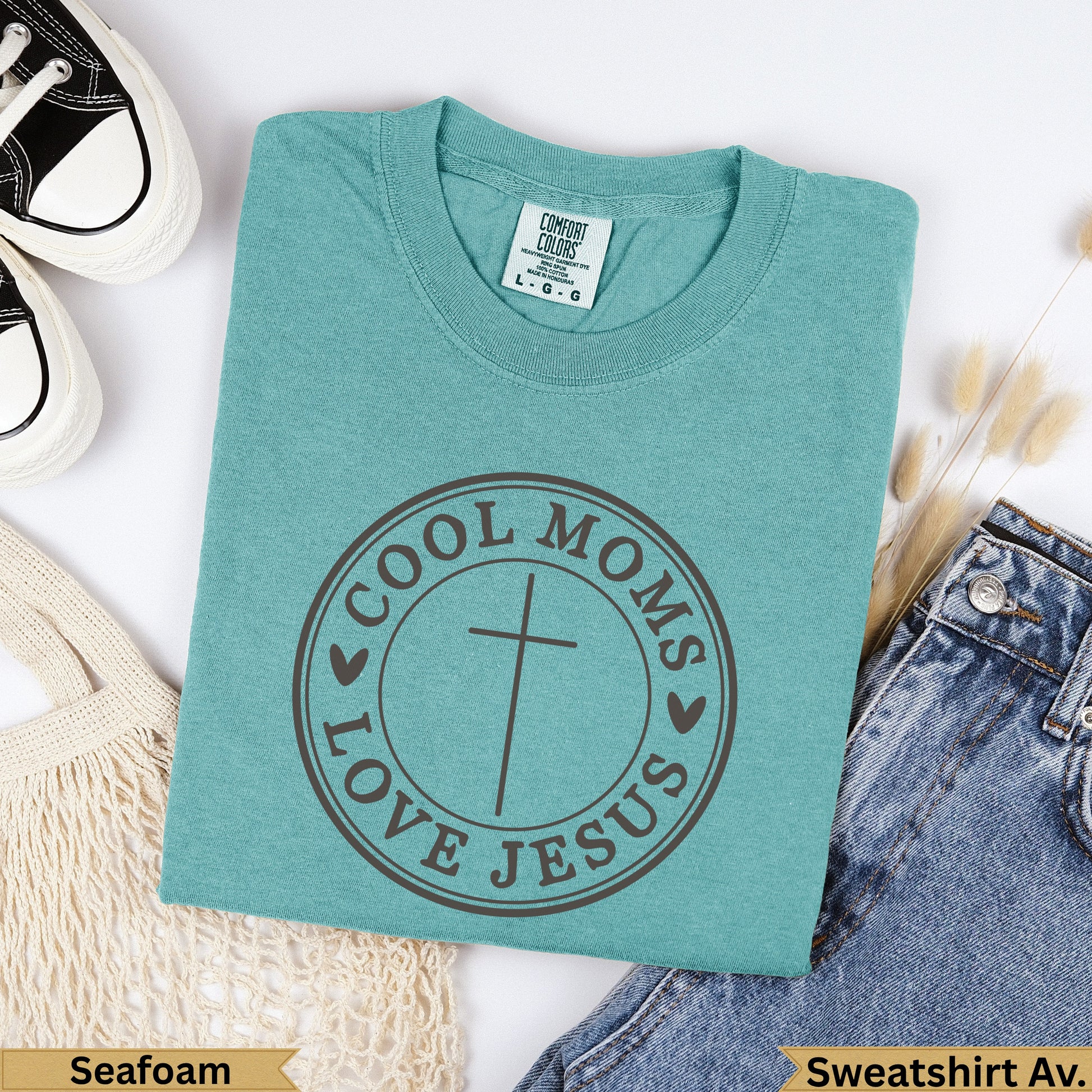 Teal Comfort Colors sweatshirt with "Cool Moms Love Jesus" circular graphic.