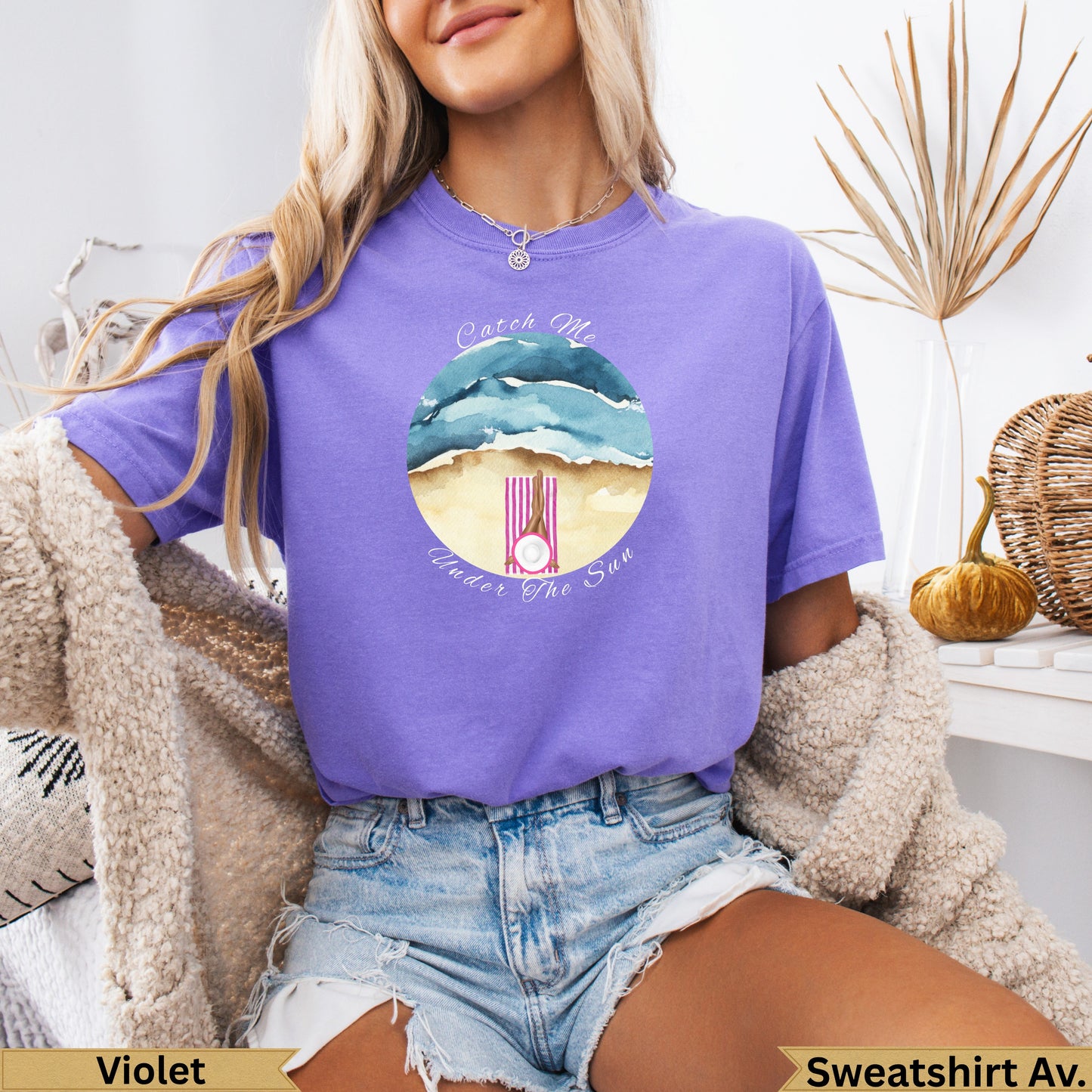 Woman in purple t-shirt with "Catch Me Under The Sun" beach graphic.