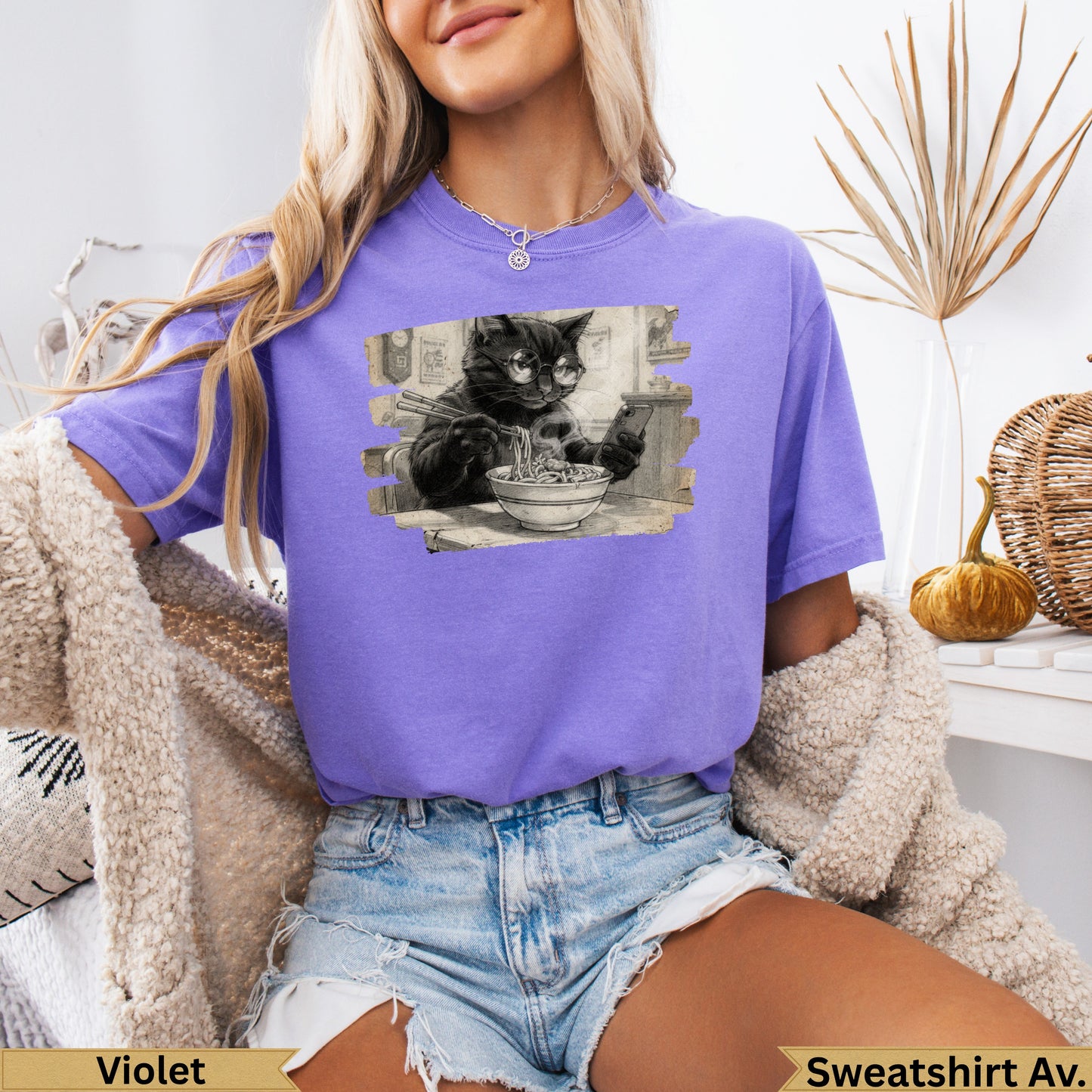 Black cat wearing glasses eats ramen noodles on purple graphic t-shirt.
