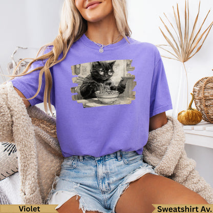 Black cat wearing glasses eats ramen noodles on purple graphic t-shirt.