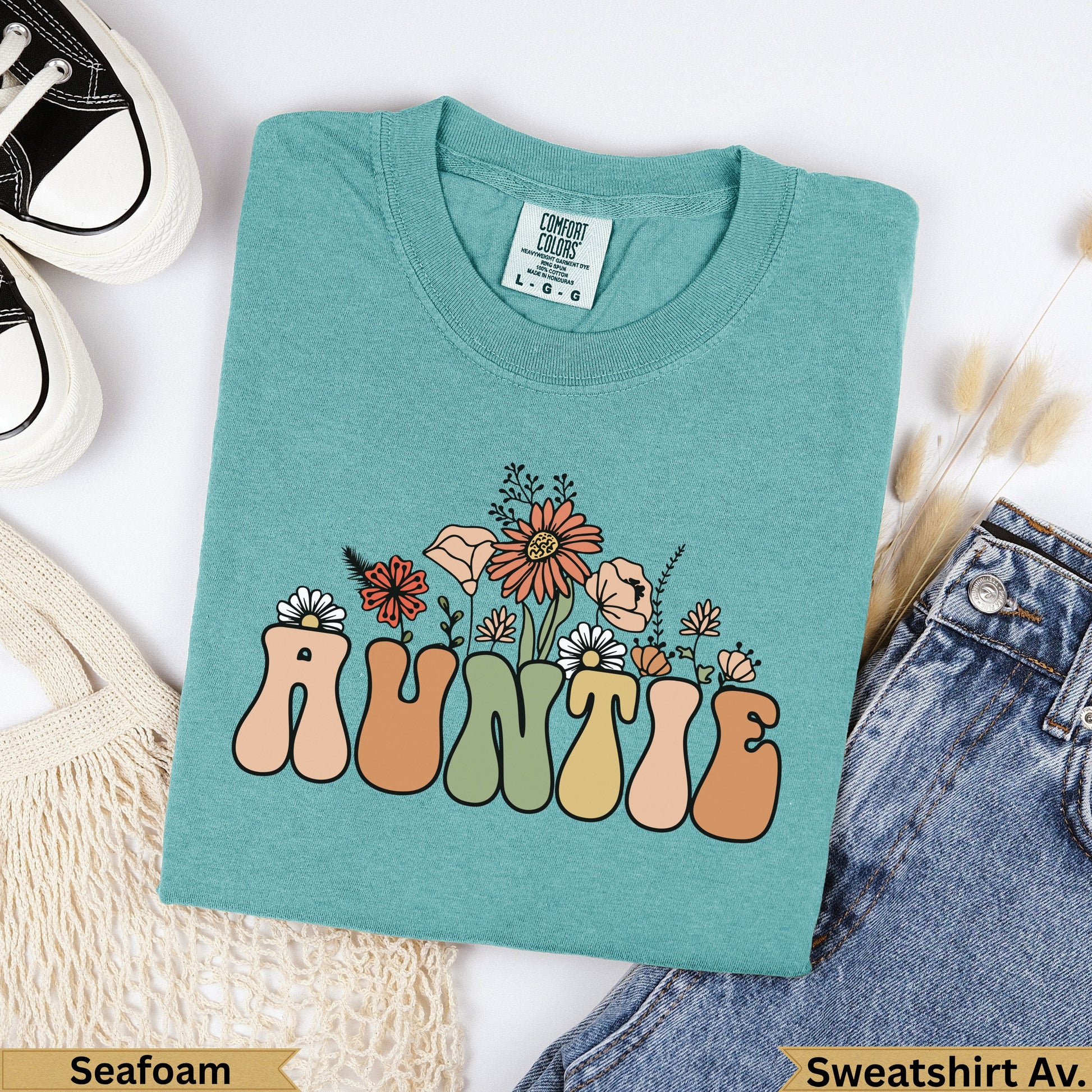 Teal crewneck sweatshirt with "AUNTIE" in retro floral lettering.