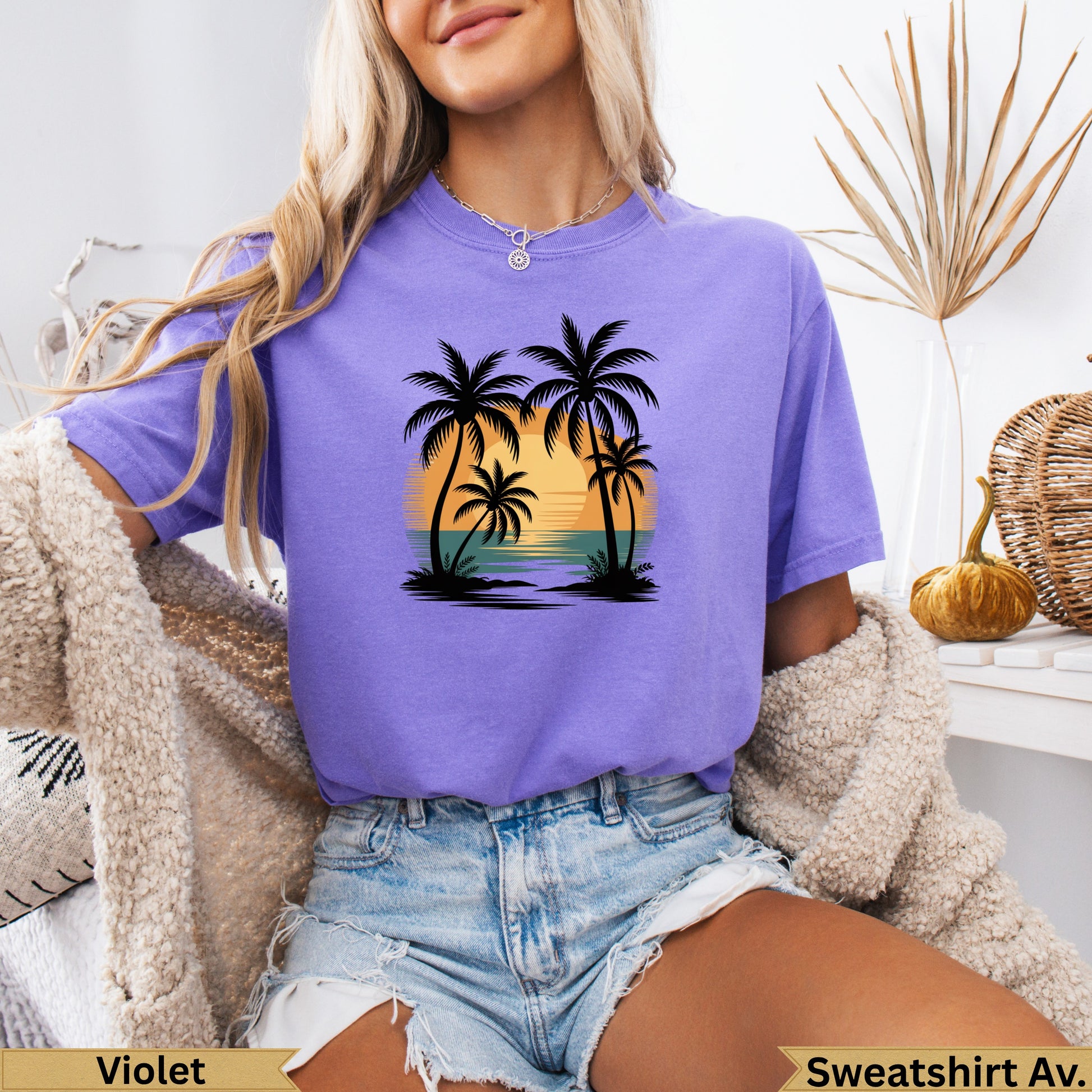 Purple t-shirt with a sunset, palm trees, and ocean graphic.