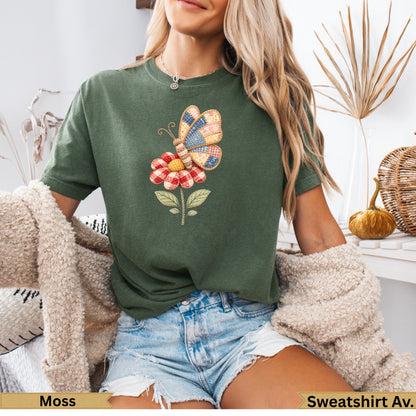 Green t-shirt with a patchwork butterfly on a flower.